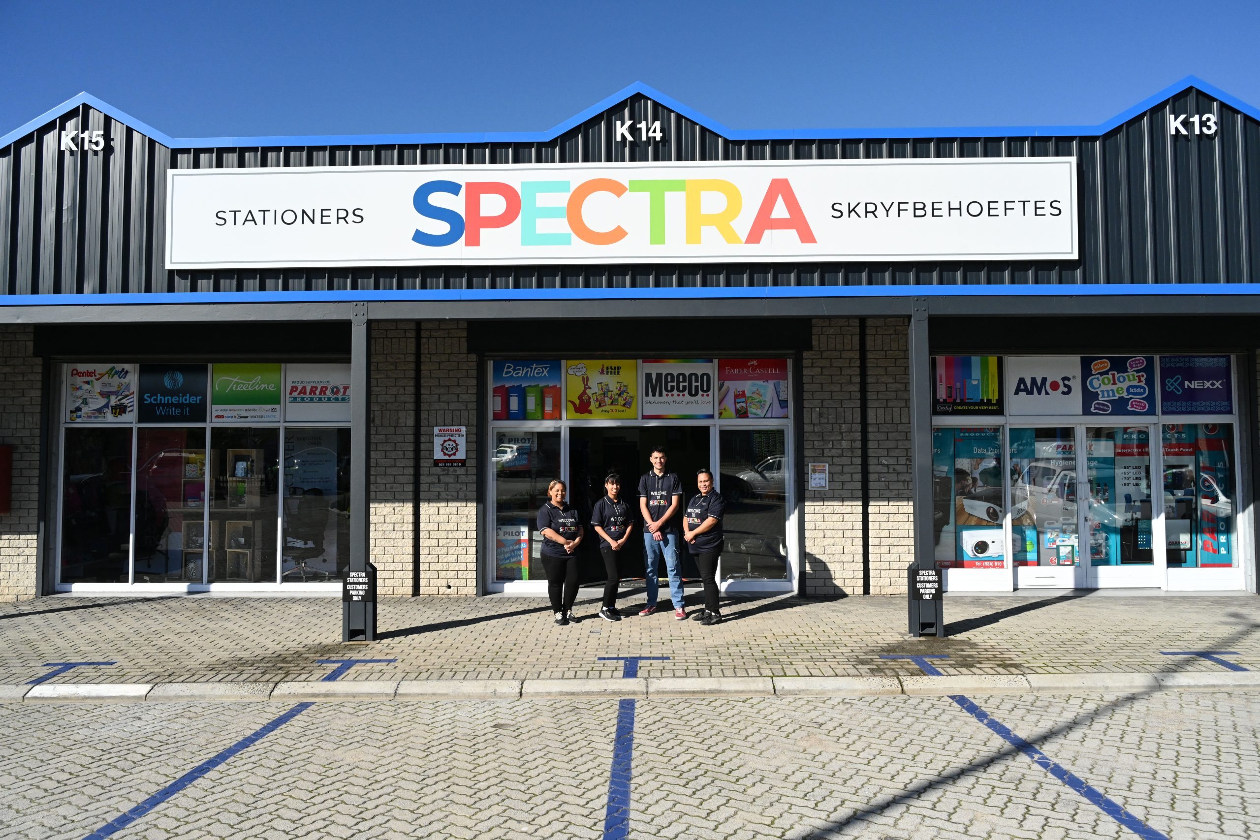 Family-owned business team standing together inside the Spectra store