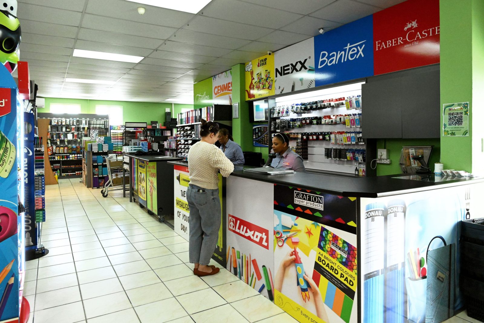 Spectra team members assisting customers in a stationery and textbook store